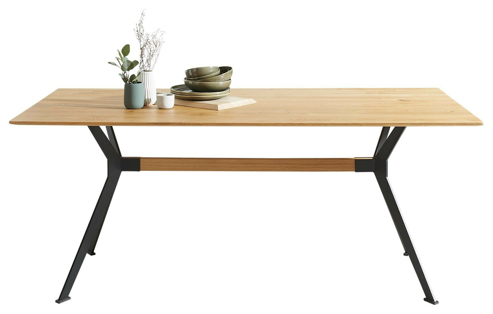 Moderner Esstisch aus Holz mit schwarzem Metallgestell, seitliche Perspektive, dekoriert mit Geschirr und Pflanzen.