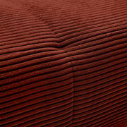 Nahaufnahme einer rotbraunen, gerippten Stoffoberfläche mit sichtbarer Naht.