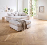 Hocker in einem modernen Wohnzimmer mit hellem Holzfußboden, im Vordergrund aus der Seitenperspektive fotografiert.