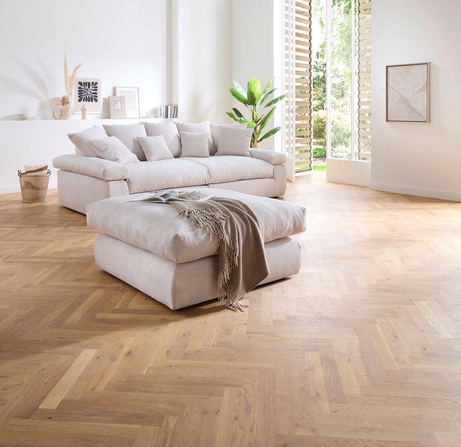 Hocker in einem modernen Wohnzimmer mit hellem Holzfußboden, im Vordergrund aus der Seitenperspektive fotografiert.