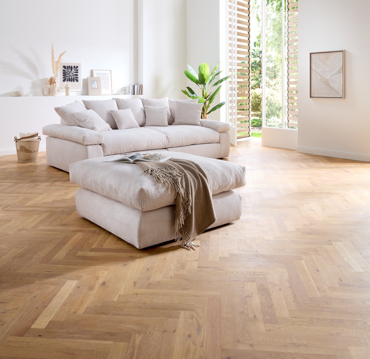 Z2 Kruk CASABLANCA Een poef in een moderne woonkamer met een lichte houten vloer, op de voorgrond gefotografeerd vanuit een zijaanzicht.