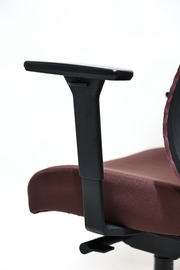 Nahaufnahme eines Drehstuhls mit brauner Rückenlehne und schwarzer Armlehne, seitliche Perspektive