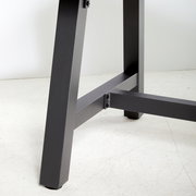 Nahaufnahme eines Tischbeins eines Gartentisches aus Metall, seitliche Perspektive