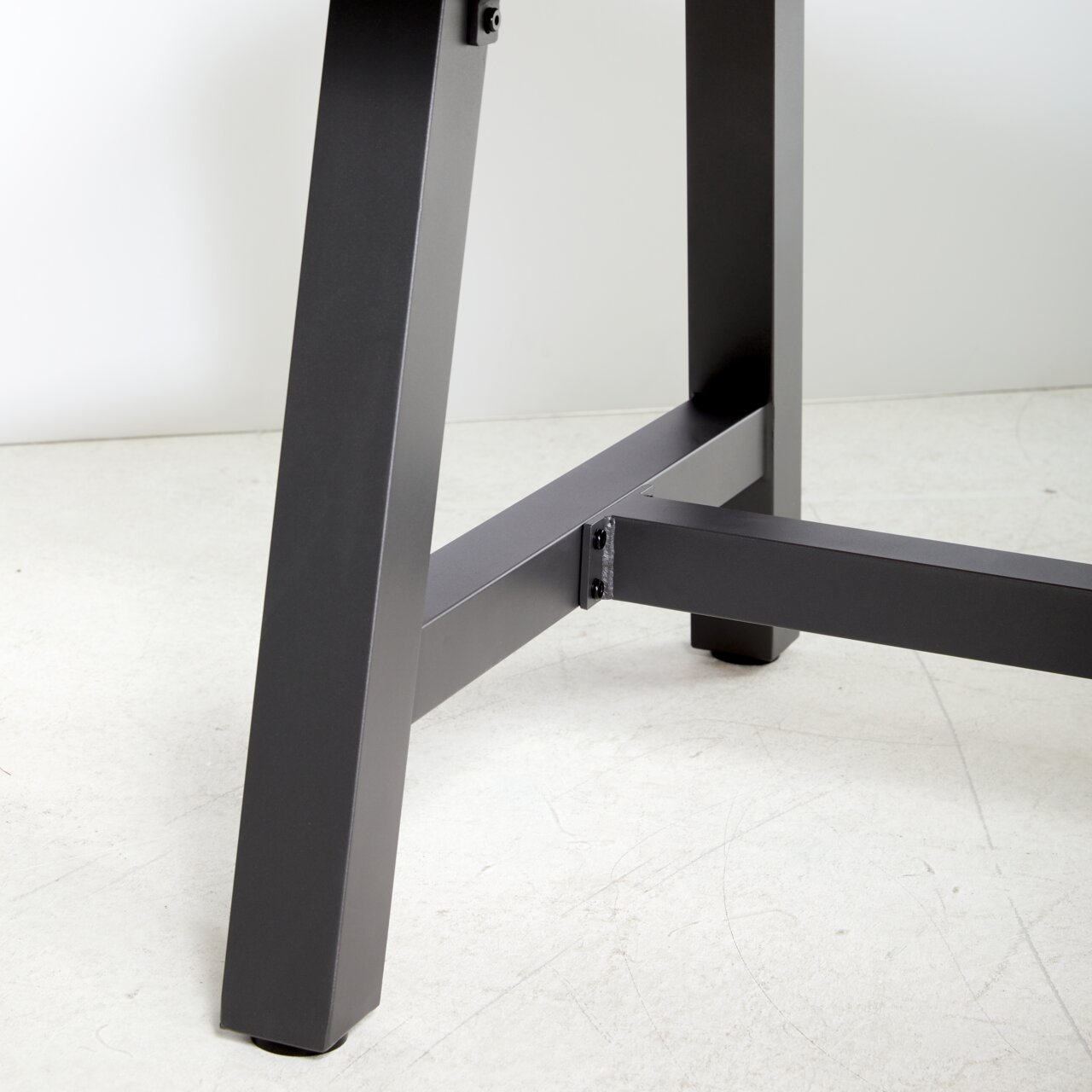 Nahaufnahme eines Tischbeins eines Gartentisches aus Metall, seitliche Perspektive