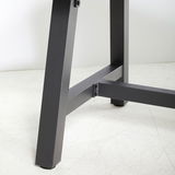 Nahaufnahme eines Tischbeins eines Gartentisches aus Metall, seitliche Perspektive