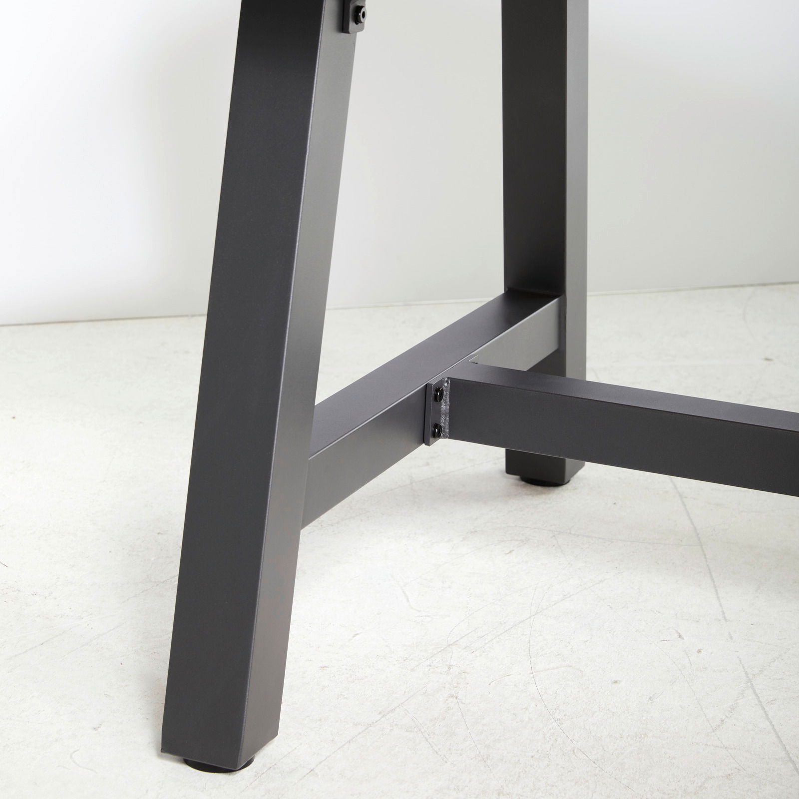 Nahaufnahme eines Tischbeins eines Gartentisches aus Metall, seitliche Perspektive