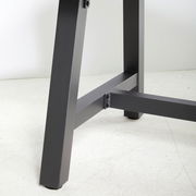 Nahaufnahme eines Tischbeins eines Gartentisches aus Metall, seitliche Perspektive