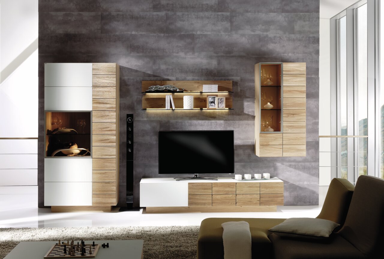 Moderne Wohnwand in Holzoptik mit TV-Schrank, Hängeschränken und Regalen, frontal betrachtet.