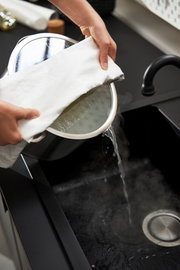 Topfset 5tlg. True Flow in der Küche, Wasser wird aus einem Topf in die Spüle gegossen, seitliche Perspektive