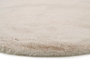 Nahaufnahme eines weichen, beigen Fellteppichs mit flauschiger Textur.