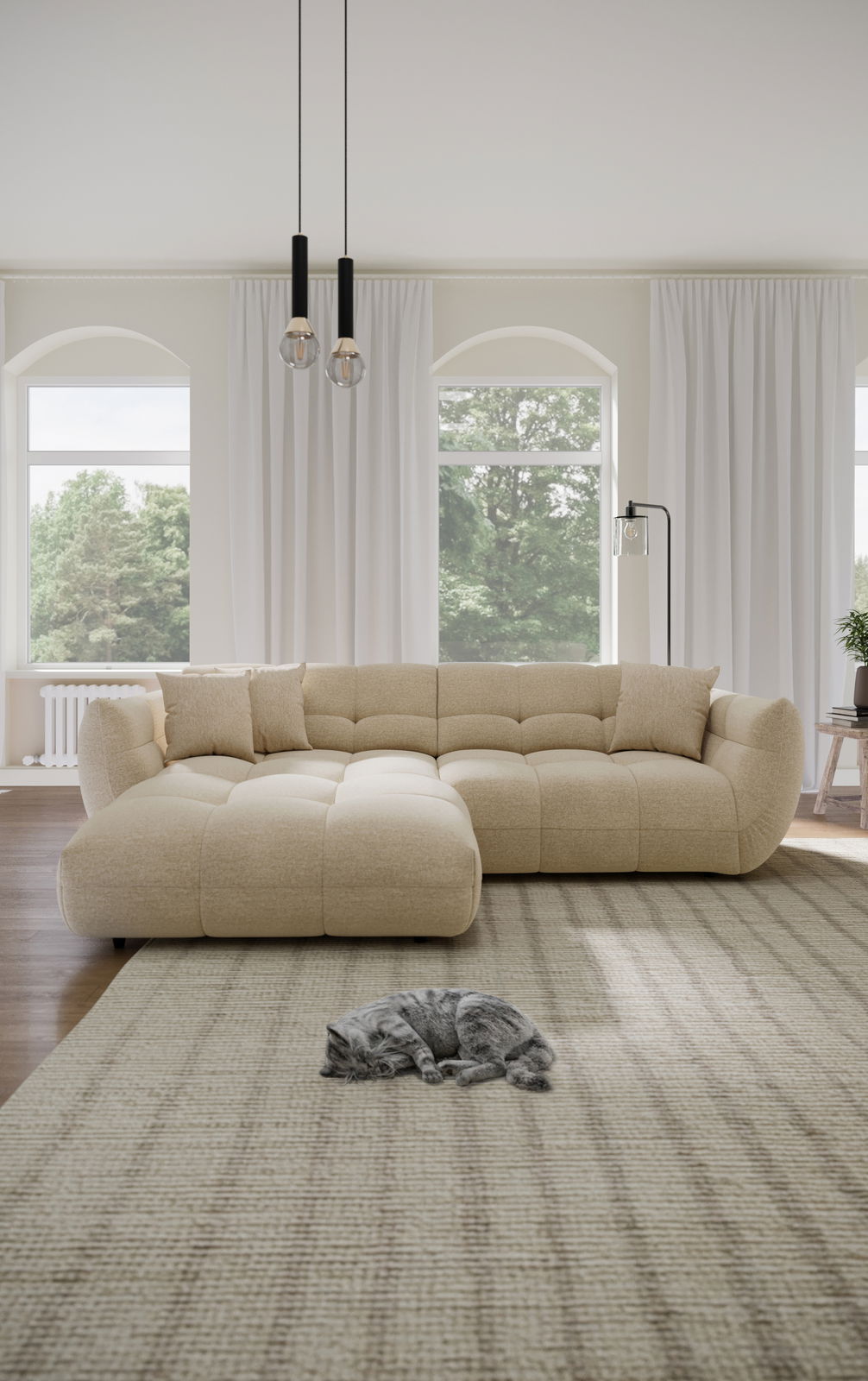Beige Ecksofa in einem hellen Wohnzimmer mit großen Fenstern, zwei Kissen und einer schlafenden Katze auf einem Teppich. Perspektive von vorne.