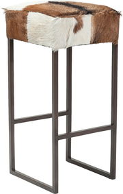 Moderner Hocker mit Fellbezug in Braun- und Weißtönen, seitliche Perspektive