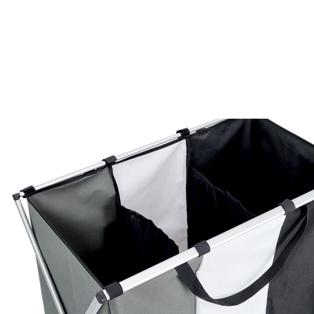 Dreifacher Wäschesammler mit drei Fächern in Schwarz, Weiß und Grau, aus der Vogelperspektive fotografiert.