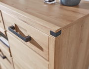 Nahaufnahme eines modernen Schuhschranks aus Holz mit schwarzen Griffen, Perspektive von oben.