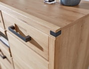 Nahaufnahme eines modernen Schuhschranks aus Holz mit schwarzen Griffen, Perspektive von oben.
