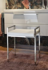 Moderner Badhocker mit Metallrahmen und weißem Sitzpolster, seitliche Perspektive