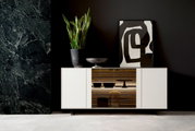 Modernes Sideboard in Weiß mit mittigem Holzregal, dekoriert mit einer Pflanze und Kunstobjekten, frontal betrachtet.