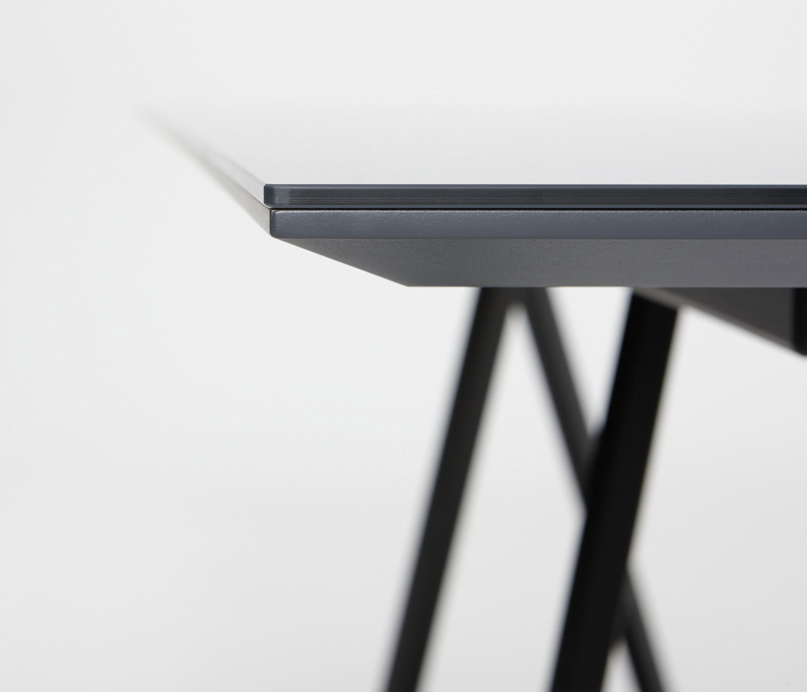 Nahaufnahme der Tischkante des JOOP! Esstisch SWING mit schwarzem Gestell, seitliche Perspektive
