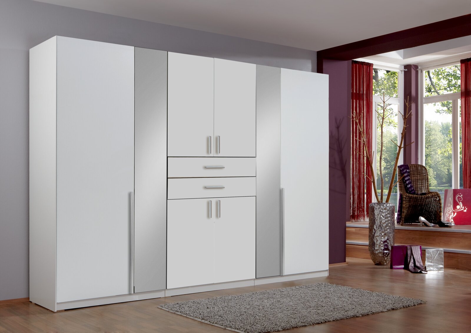Moderner weißer Drehtürenschrank mit sechs Türen und zwei Schubladen, frontal abgebildet in einem stilvollen Raum mit großen Fenstern.