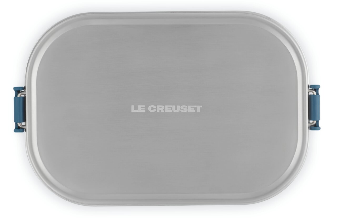 Obere Ansicht einer rechteckigen Lunchbox in Deep Teal mit silbernem Deckel und blauen Verschlüssen, Marke Le Creuset.