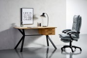 Moderner Schreibtisch aus Holz mit schwarzen Metallbeinen, zwei Schubladen und einer Tischlampe, seitliche Perspektive.
