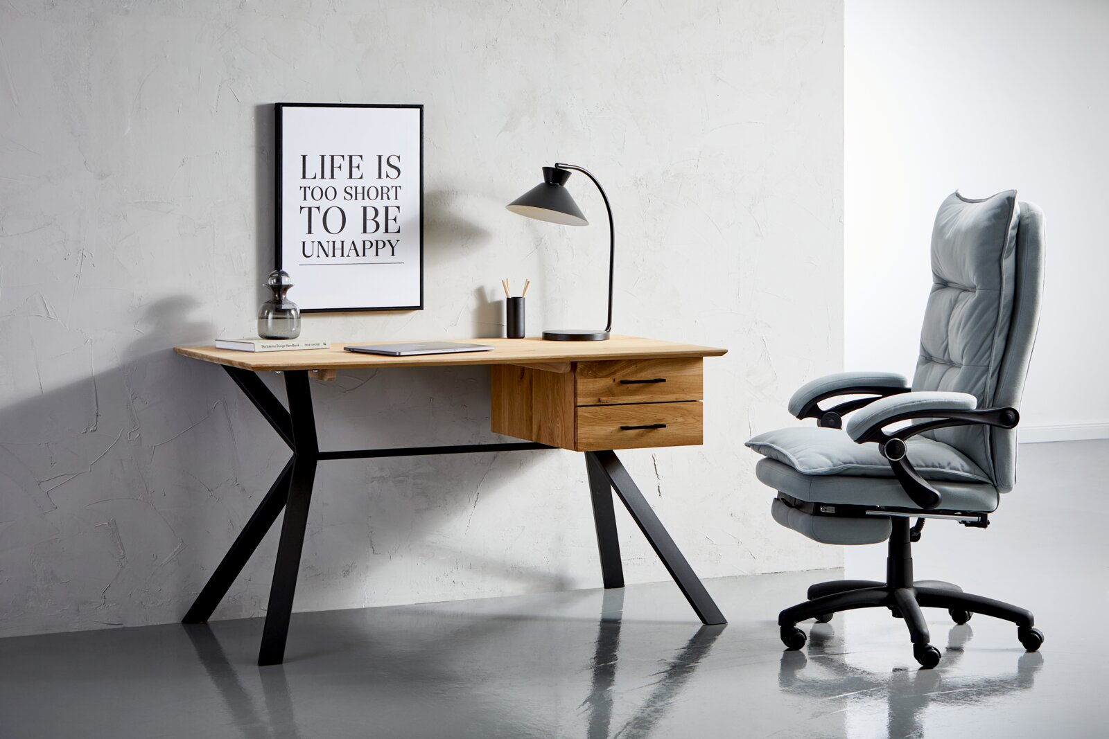 Linea Natura Bureau WINTERTUR Moderner Schreibtisch aus Holz mit schwarzen Metallbeinen, zwei Schubladen und einer Tischlampe, seitliche Perspektive.