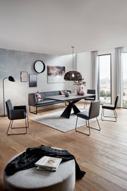 Moderner Esstisch mit schwarzem Metallgestell und dunkler Tischplatte, umgeben von stilvollen Stühlen in einem eleganten Esszimmer mit Blick aus der Fensterperspektive.