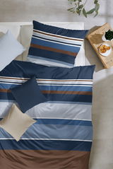 Bettwäsche-Set in Blau- und Brauntönen mit Streifenmuster, von oben fotografiert, auf einem Bett mit Kissen und einem kleinen Tisch mit Snacks.