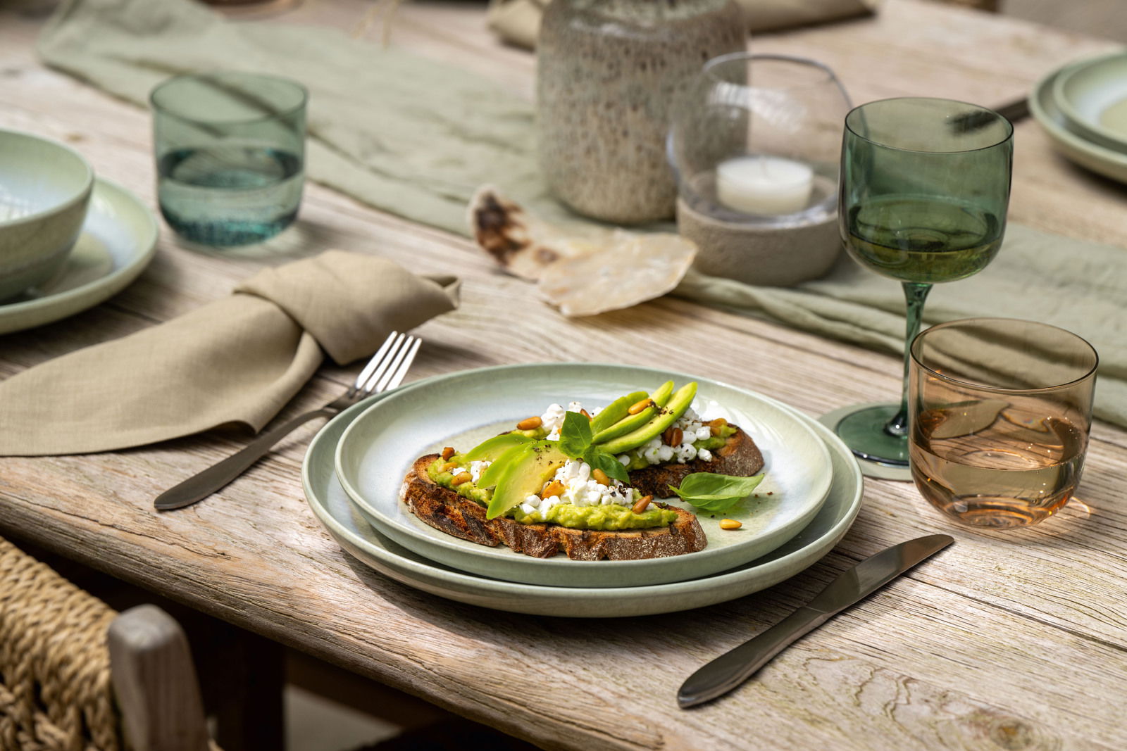 Like by Villeroy & Boch Frühstücksteller PERLEMOR ALGA Frühstücksteller mit Avocado-Toast, von schräg oben fotografiert, auf einem gedeckten Tisch mit grünem Geschirr und Gläsern.