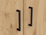 Nahaufnahme von zwei schwarzen Griffen an einer Holztür eines Mehrzweckschranks, aus der Frontalperspektive.