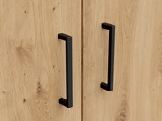Nahaufnahme von zwei schwarzen Griffen an einer Holztür eines Mehrzweckschranks, aus der Frontalperspektive.