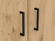 Close-up van twee zwarte handgrepen op een houten deur van een multifunctionele kast, gezien van voren.