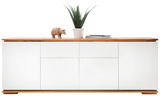 Frontansicht eines weißen XL-Sideboards mit Holzoberfläche, dekoriert mit einer Pflanze, einem Holzdekor und Zeitschriften.