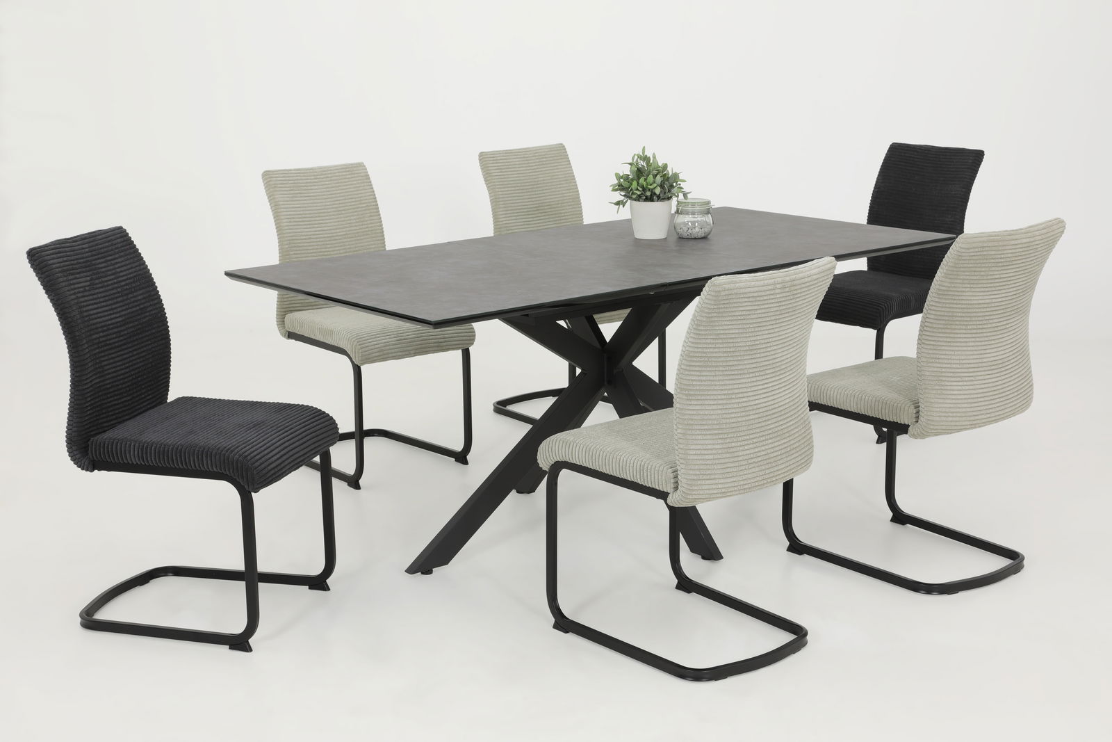 Esszimmer mit modernem Tisch und sechs Schwingstühlen in verschiedenen Farben, seitliche Perspektive