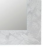 Nahaufnahme eines rechteckigen Spiegels mit dekorativem, strukturiertem Rahmen in Weiß, perspektivisch von der Ecke aufgenommen.