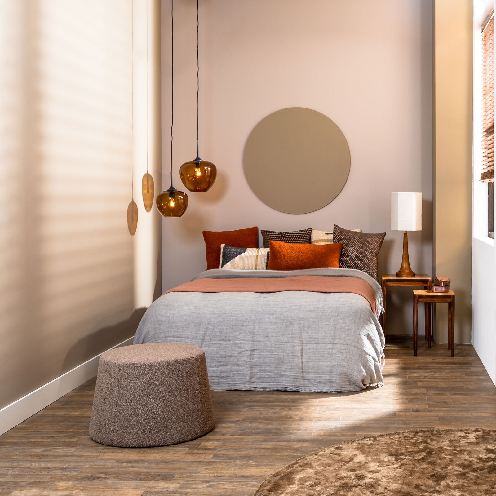 Moderne Hängeleuchte in einem stilvoll eingerichteten Schlafzimmer, aus der Perspektive vom Fußende des Bettes aufgenommen.