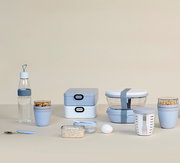 Verschiedene Bento-Lunchboxen und Behälter in Pastellfarben, frontal fotografiert auf einem neutralen Hintergrund.