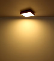 Quadratische Deckenleuchte mit warmem Licht, von unten betrachtet.