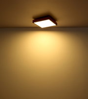 Quadratische Deckenleuchte mit warmem Licht, von unten betrachtet.