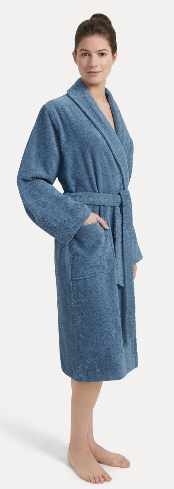 Vrouw in een blauwe badjas met sjaalkraag, zijaanzicht