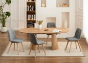 Esszimmer mit einem ovalen Holztisch und vier grauen Stühlen, seitliche Perspektive.