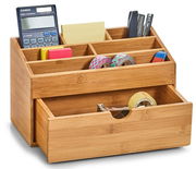 Bambus-Organizer mit Schubfach, gefüllt mit Büroartikeln wie Taschenrechner, Haftnotizen, Klebeband und Stiften, aus einer leicht seitlichen Perspektive.
