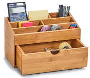 Bambus-Organizer mit Schubfach, gefüllt mit Büroartikeln wie Taschenrechner, Haftnotizen, Klebeband und Stiften, aus einer leicht seitlichen Perspektive.