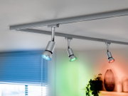 LED-lampen in een moderne plafondlamp met drie spotjes die in verschillende kleuren schijnen. Aanzicht van onderaf.