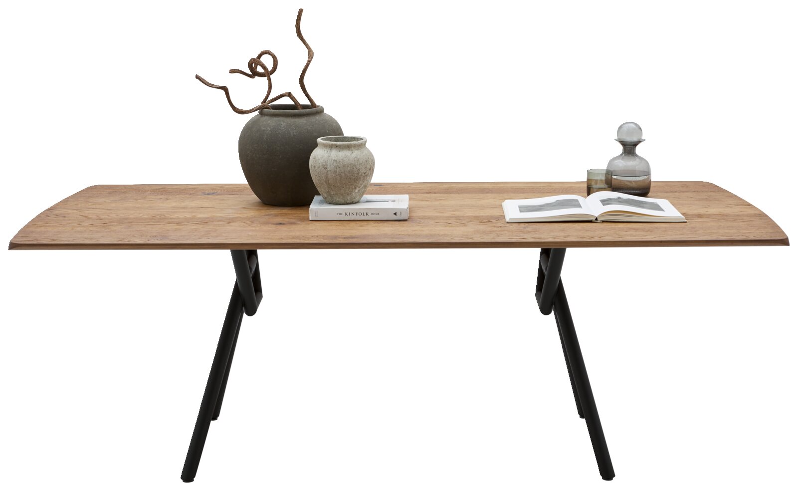 Rechthoekige houten eettafel met afgeronde hoeken en zwarte metalen poten, frontaal aanzicht op witte achtergrond, gestyled met vazen, boek en karaf.