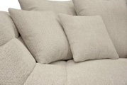 Nahaufnahme in schräger Vorderansicht: hellbeiges Sofa mit strukturierter Stoffpolsterung und zwei passenden Zierkissen