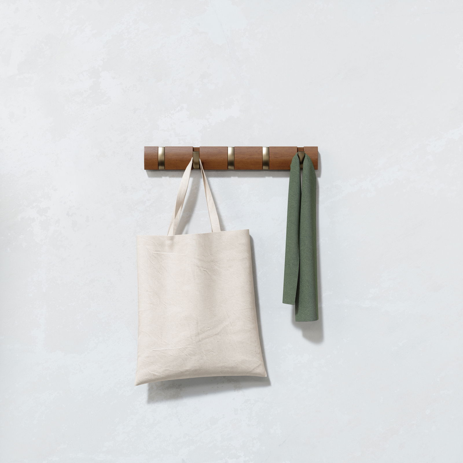 Wandgarderobe aus Holz mit fünf Haken, an denen eine beige Stofftasche und ein grünes Tuch hängen, frontal betrachtet.