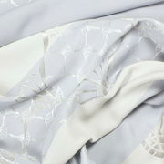 Detailansicht eines Ösenvorhangs mit elegantem Muster in hellen Tönen.