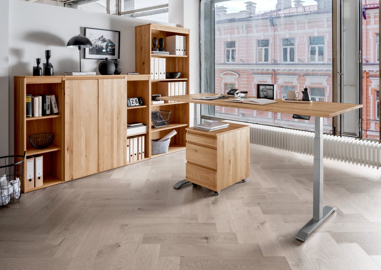 Moderne kantoormeubelcombinatie van hout met een in hoogte verstelbaar bureau, een rolcontainer en planken, gezien vanaf de zijkant.