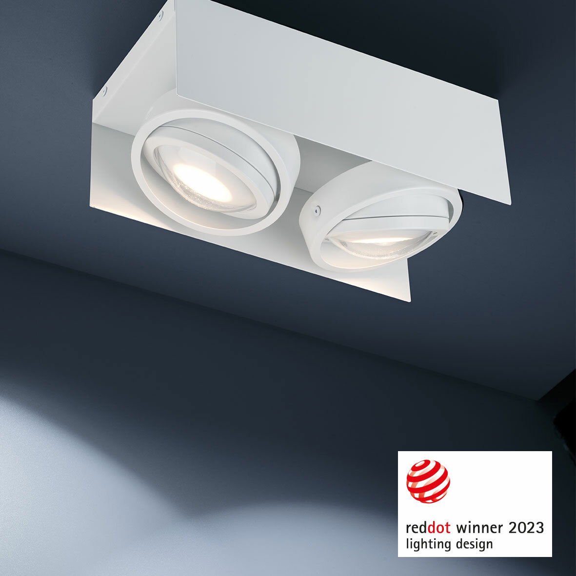 Moderne LED Aufbauleuchte mit zwei runden Strahlern, Deckenansicht, ausgezeichnet mit dem Red Dot Award 2023.